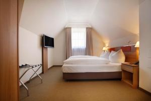a hotel room with a bed and a television at Hotel am Jakobsmarkt in Nuremberg
