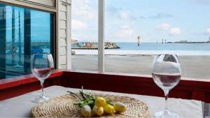 two wine glasses on a table with a view of the ocean at Goseong Badasga per Osyeonbyu Pension in Goseong