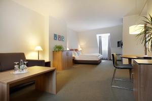 a hotel room with a bed and a living room at Hotel am Jakobsmarkt in Nuremberg