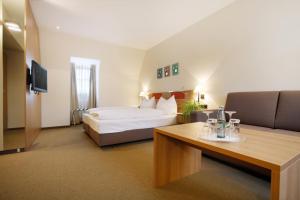 a hotel room with a bed and a couch at Hotel am Jakobsmarkt in Nuremberg