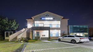 a white car parked in front of a building at Jeju Badagreen Pension in Jeju +1 photo