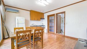 a kitchen with a table and chairs and a refrigerator at Ganghwa Dondaemoru pension in Incheon