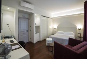 a hotel room with a bed and a couch at Town House Morgana in Reggio Calabria