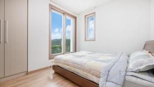 a bedroom with a bed and a large window at Samcheok Santorini Pension in Samcheok