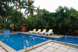 a swimming pool with lounge chairs next to a resort at Morjim Hermitage in Morjim