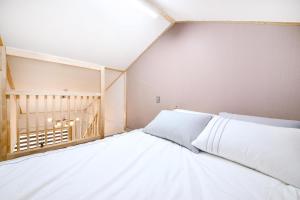 a white bed in a room with a window at Gangneung Raon Pension in Gangneung