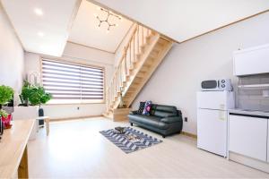 a living room with a couch and a kitchen at Gangneung Raon Pension in Gangneung