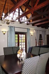 Una mesa de comedor con un osito de peluche en un jarrón encima. en Clarens Charm, en Clarens