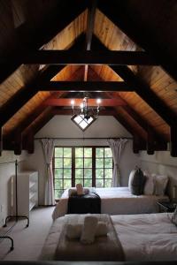 Un dormitorio con dos camas y una gran ventana. en Clarens Charm, en Clarens
