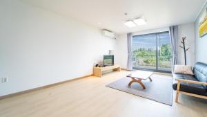 un soggiorno con un divano e un tavolo di Jeju ChunJaNe Pension a Seogwipo Altre 5 foto