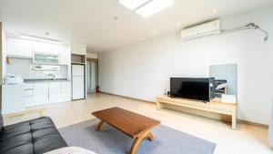 un soggiorno con un divano e un tavolo di Jeju ChunJaNe Pension a Seogwipo