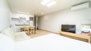 una camera con letto e un soggiorno con cucina di Jeju ChunJaNe Pension a Seogwipo