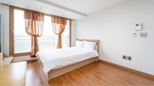 a bedroom with a bed and a large window at jeju ondamhouse pension in Jeju