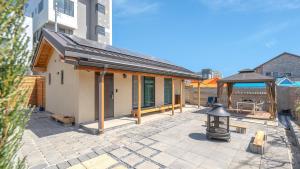 a building with a gazebo on a patio at Gangneung Gangmunsosodam Pension in Gangneung