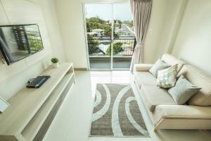 a living room with a couch and a window at Central Place Serviced Apartment Angsila in Ang Sila