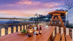 three bottles of beer sitting on a wooden table at Ganghwa Nakjohealing Caravan&Camping in Incheon