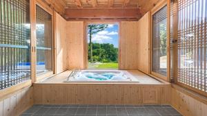 jacuzzi en una habitación con ventana en Gangneung Booyoonok Hanok Pension, en Gangneung