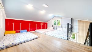 a room with four beds in it with a red wall at Chuncheon thegangchon pension in Chuncheon