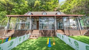 a house with a green yard with cones at Gapyeong Daengdaengi Dog Pension Silver in Gapyeong