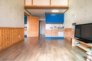 a large kitchen with wooden floors and blue cabinets at Ganghwa nolumog byeoljang in Incheon