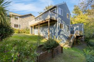 a home with a blue house with a deck at Royal Canoe by AvantStay Walk to the Shore Private Yard in Arch Cape