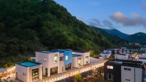 an aerial view of a building with mountains in the background at Gapyeong Villajia Spa Pension in Gapyeong