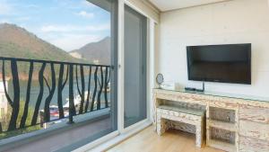 un soggiorno con una grande finestra e una TV a schermo piatto di Gapyeong Applerotgi Pension a Gapyeong