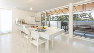 a white kitchen with a table and some chairs at Samcheok Migaloo Pool Villa Pension in Samcheok