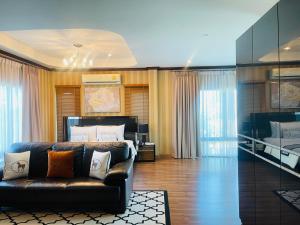a living room with a couch and a bed at Romlaphass Boutique Villa in Kalasin