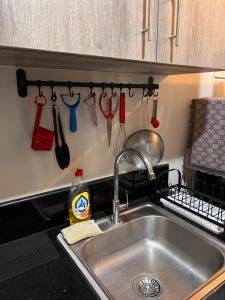 a kitchen sink with utensils hanging on a wall at SMDC Coast Residences by Presto Real Estate Management near MOA, PICC, Star City and NAIA in Manila