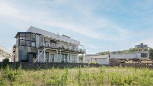 a house with a balcony on the side of it at Gangneung Remember Dogchae Pension in Gangneung
