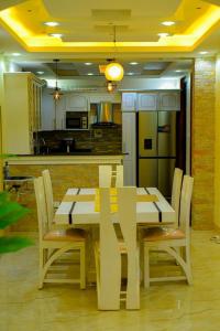 a kitchen with a white table and chairs and a kitchen with a kitchen at Gloria Villas in Entebbe