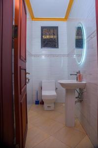 a bathroom with a sink and a toilet and a window at Gloria Villas in Entebbe
