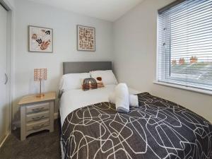 a bedroom with a bed and a table and a window at Cozy 2-Bed Belfast Apartment in Belfast
