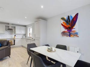a kitchen and dining room with a table and chairs at Cozy 2-Bed Belfast Apartment in Belfast
