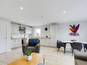 a kitchen and living room with a table and chairs at Cozy 2-Bed Belfast Apartment in Belfast
