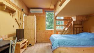 una camera con letto, TV e scale di Jeju Jeonwonsaenghwal Diorem Pension a Jeju