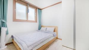 a small bed in a room with a window at Samcheok Bongsuni-unni Pension in Samcheok