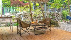 a table and two chairs on a wooden deck at Gapyeong Yumyeongsan Gomone pet Camping in Gapyeong +3 photos