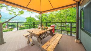 a wooden table with an umbrella on a balcony at Gapyeong Yumyeongsan Gomone pet Camping in Gapyeong