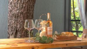 a bottle of wine and two glasses on a wooden table at Gapyeong Yumyeongsan Gomone pet Camping in Gapyeong