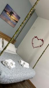 a room with a bed with towels and a heart on the wall at Villa COME A CASA TUA in Bari