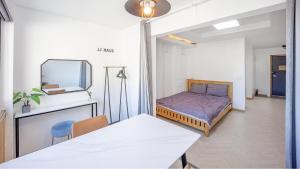 a room with a bed and a table and a mirror at Namhae JJhouse Pension in Namhae
