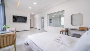 Un dormitorio blanco con una cama y un televisor. en Gapyeong Ciere Poolvilla, en Gapyeong