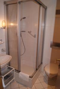 ein Bad mit einer Dusche, einem WC und einem Waschbecken in der Unterkunft Hotel Zur Traube in Bad Homburg vor der Höhe