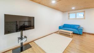 a living room with a blue couch and a tv at Jeju Hoyeongfarm Stay in Jeju +8 photos
