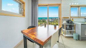 a kitchen with a wooden table and chairs and a window at Jeju Hoyeongfarm Stay in Jeju
