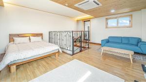 a bedroom with a bed and a couch at Jeju Hoyeongfarm Stay in Jeju