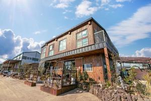 an old building with a lot of plants in front of it at Seogwipo Unyeong Pension in Seogwipo