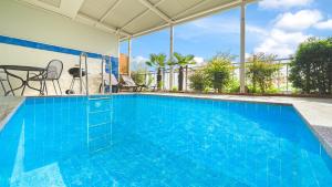 une piscine bleue avec une table et des chaises dans l'établissement Namhae Ourpoolvilla, à Namhae